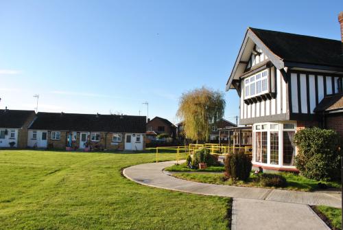 Exterior photo of main green at Beatrice Littlewood House, surrounded by bungalows and the main building.